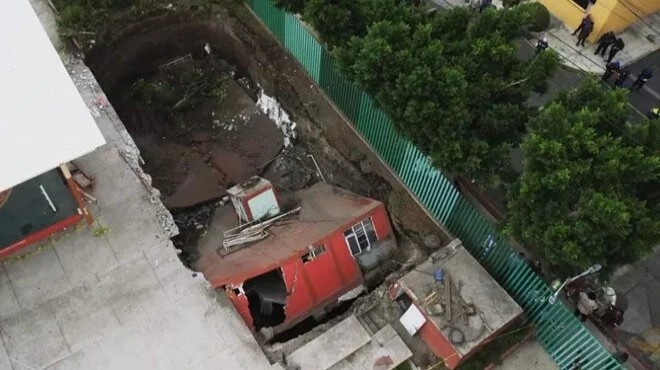 Meksika’da bir bina yolda oluşan dev çukurun içine devrildi